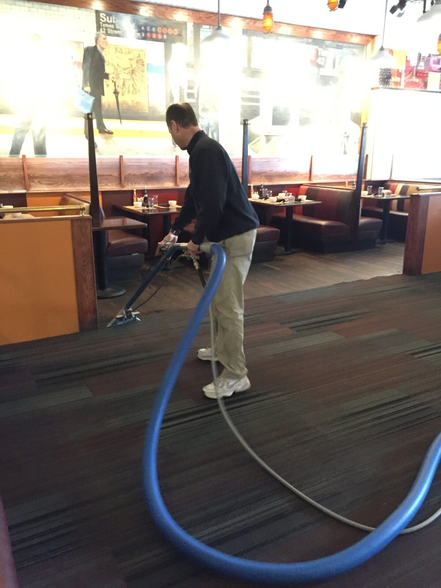 A person cleaning the floor with a vacuum cleaner